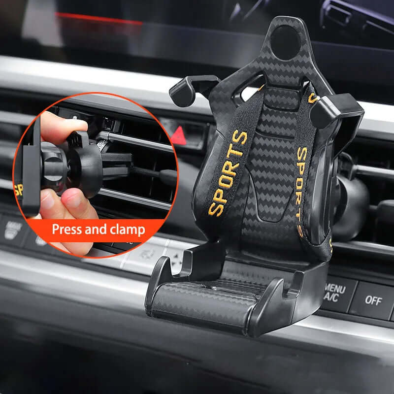 Racing seat shape car phone holder securely clamped in car air vent, featuring a press-and-clamp design for easy use.