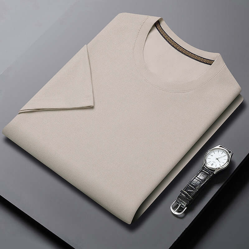 Men's breathable round neck half sleeve top in beige with a stylish watch on a black surface.