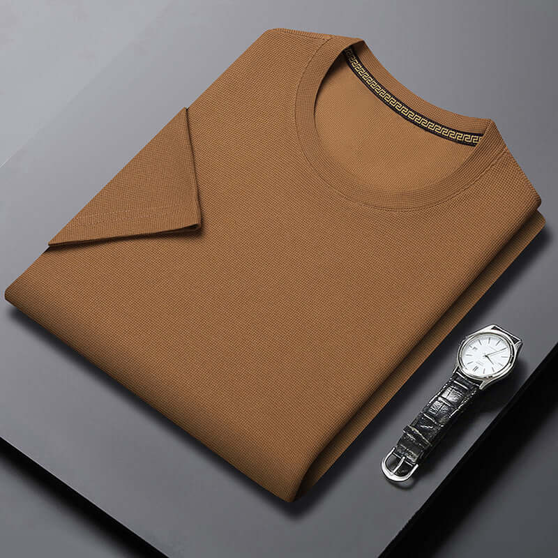 Men's all-matching round neck half sleeve top in caramel color, paired with a stylish watch on a black surface.