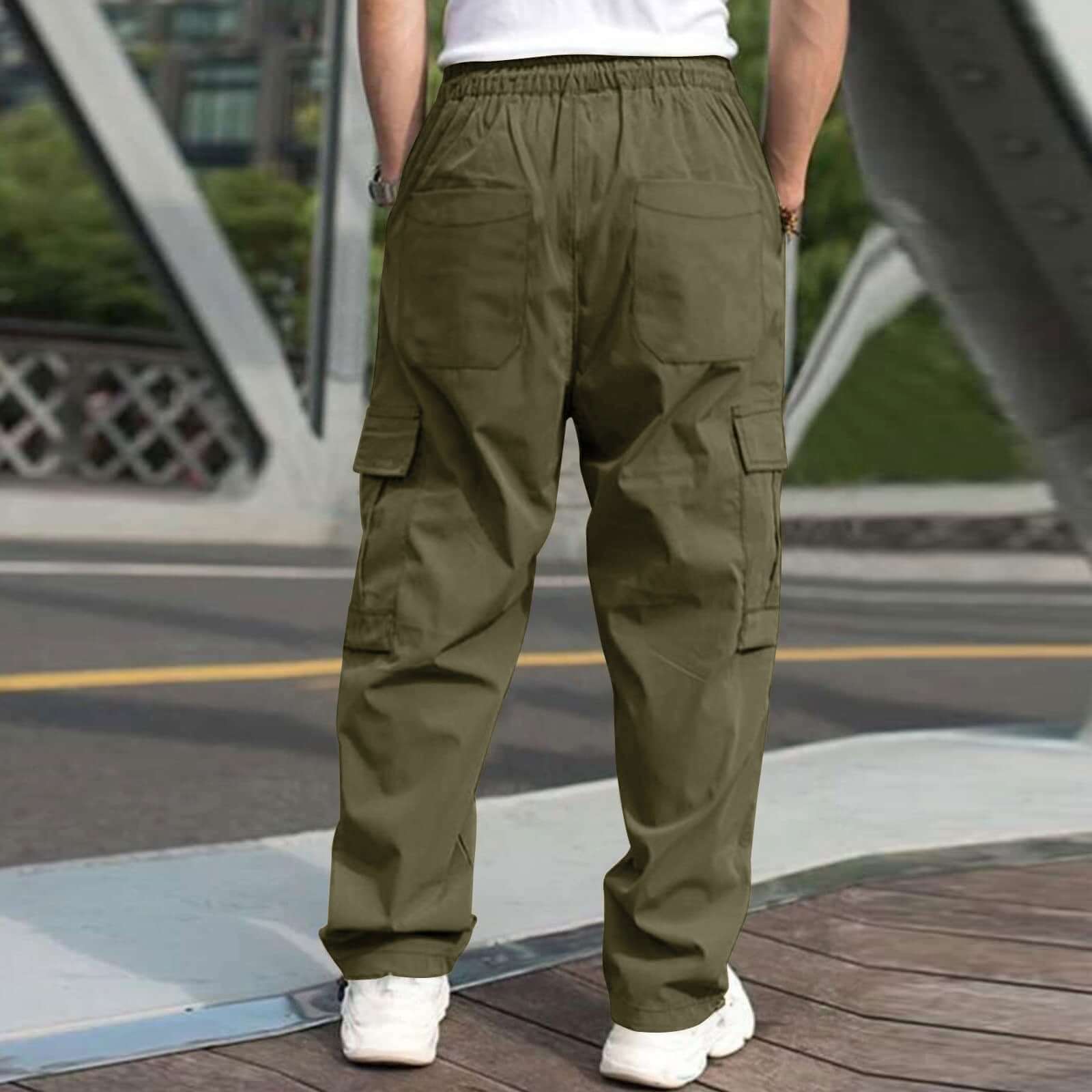 Men's casual cargo pants in army green with elastic drawstring waist and multiple pockets, styled outdoors.